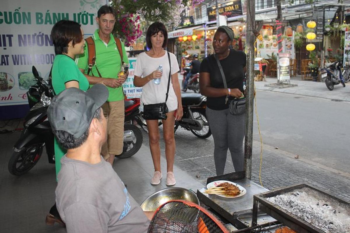 un gruppo di persone in piedi attorno a un tavolo con la pizza