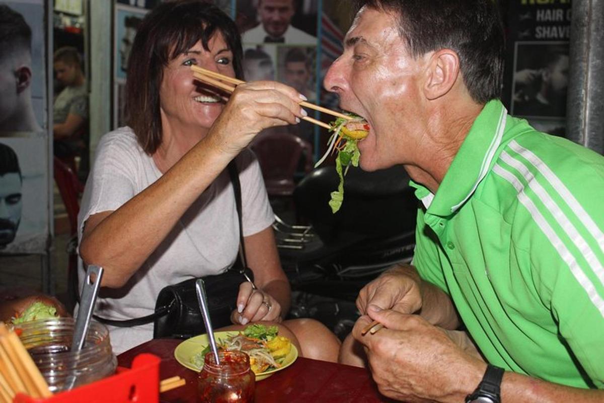 un uomo e una donna seduti a un tavolo che mangiano cibo