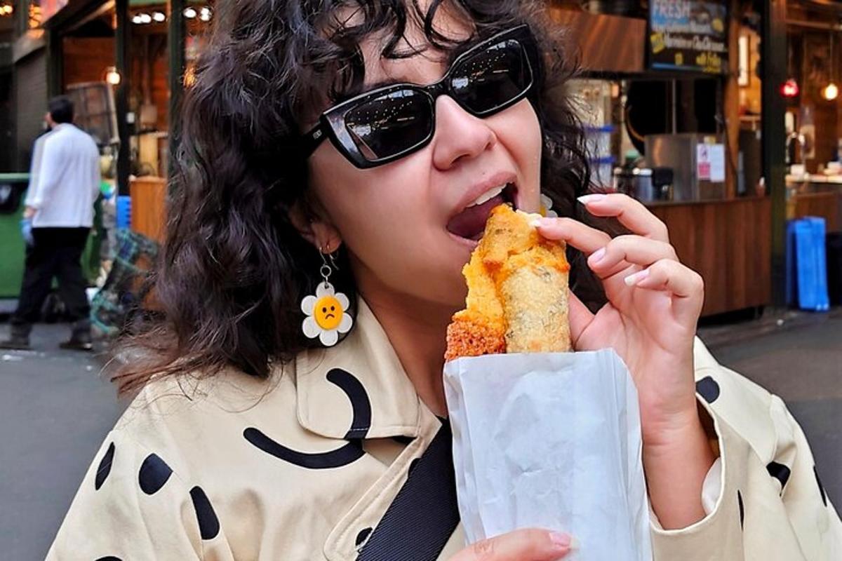 a woman in sunglasses eating a sandwich with her mouth