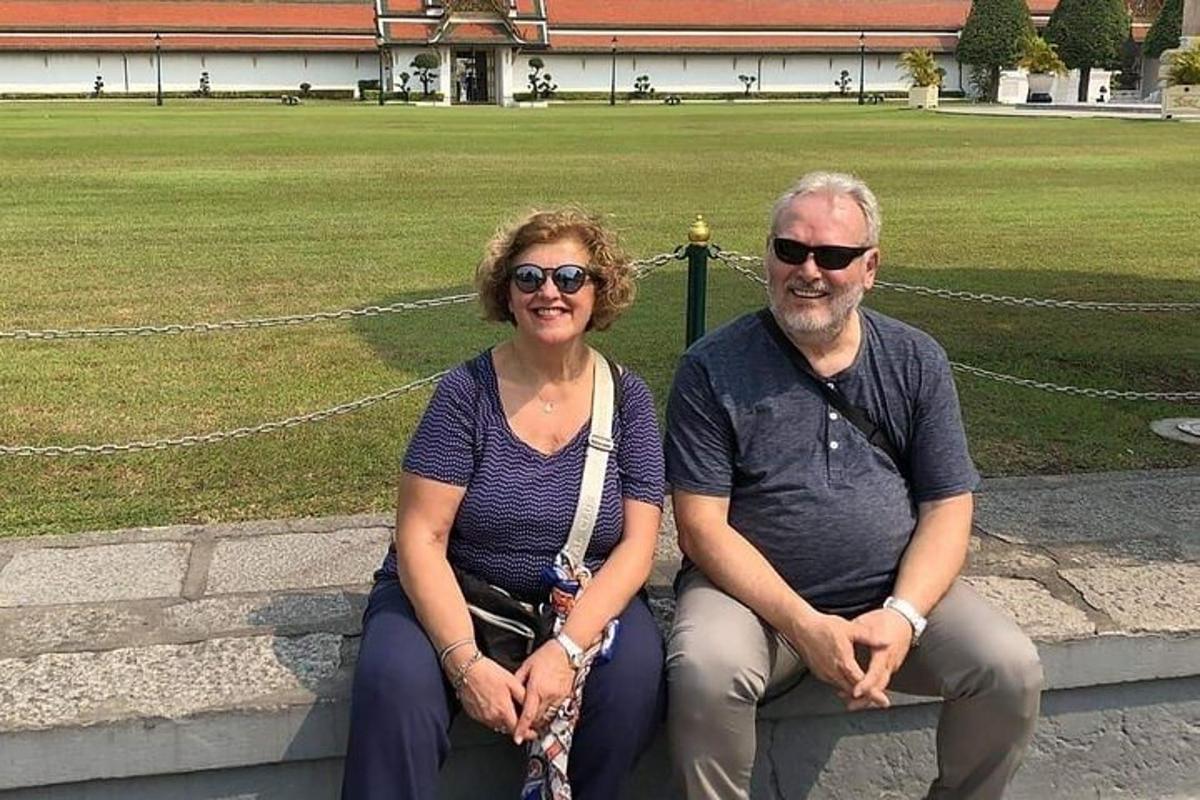 a man and woman sitting on a bench in a park