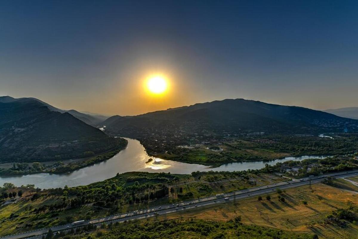 a view of a river with the sun in the sky