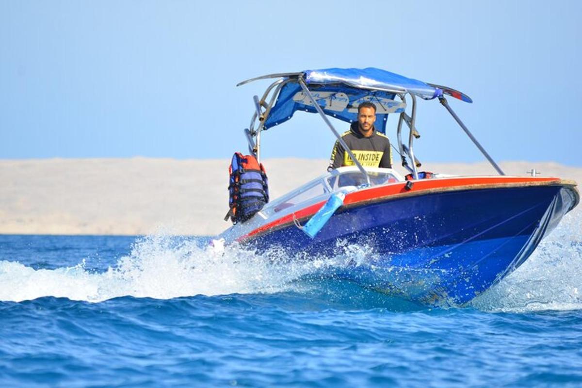 un uomo su una barca blu e rossa in acqua