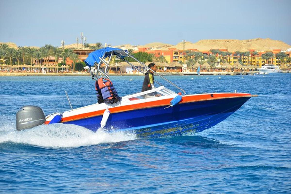 un uomo su una barca blu e arancione in acqua