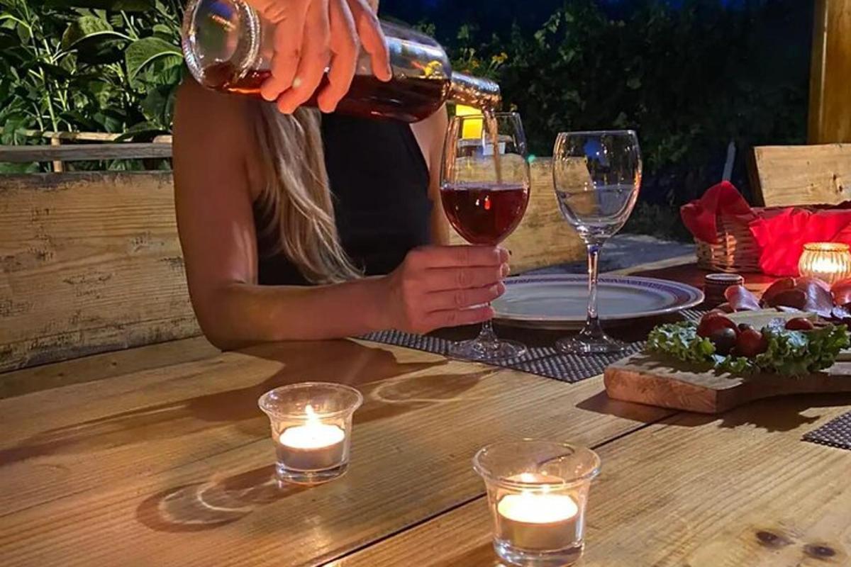 kona hellir glasi af víni á borð