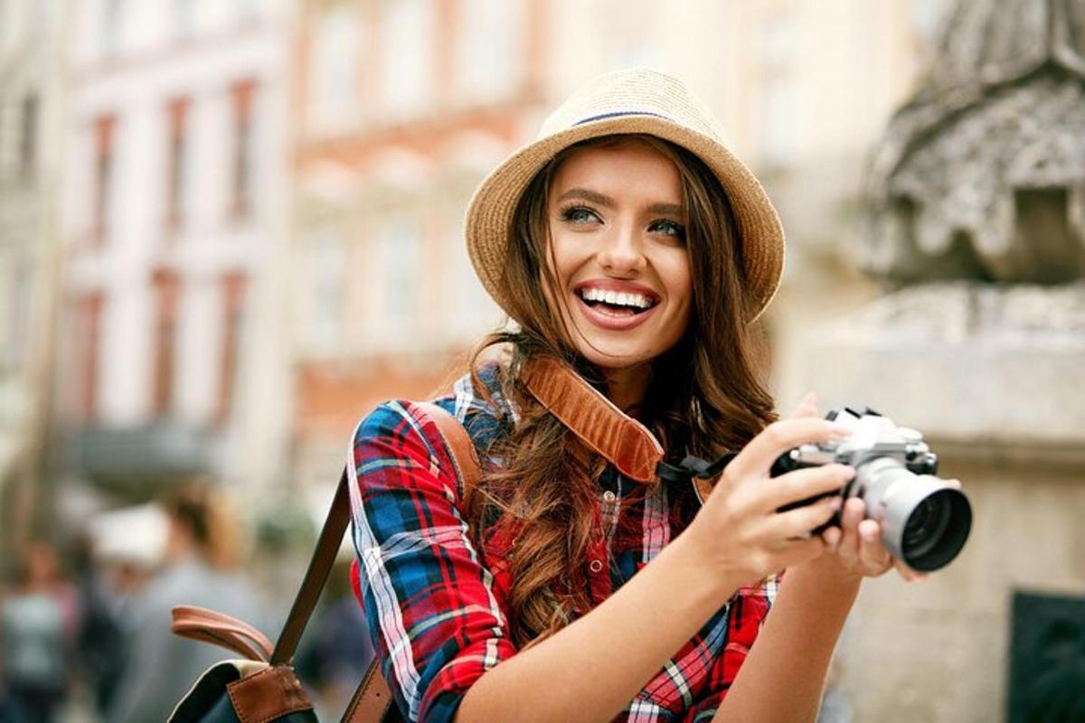 a woman in a hat taking a picture with a camera
