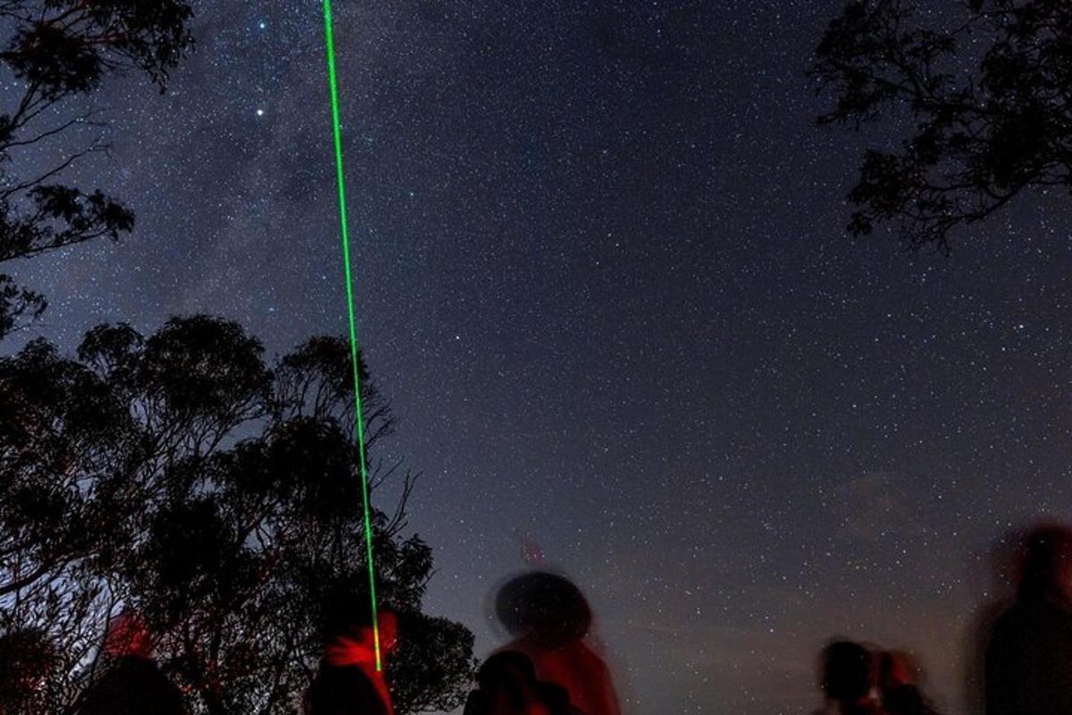 a green line is pointing at the night sky
