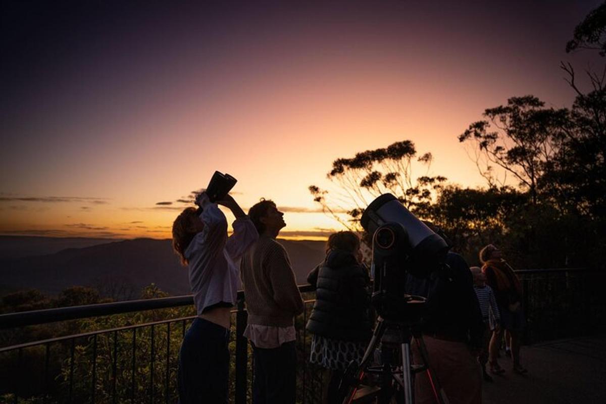 a group of people standing around watching the sunset