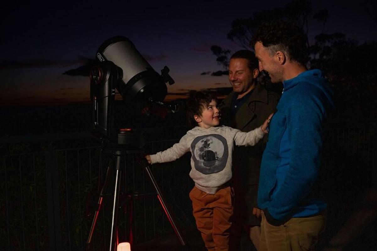 two men and a young boy looking at a telescope