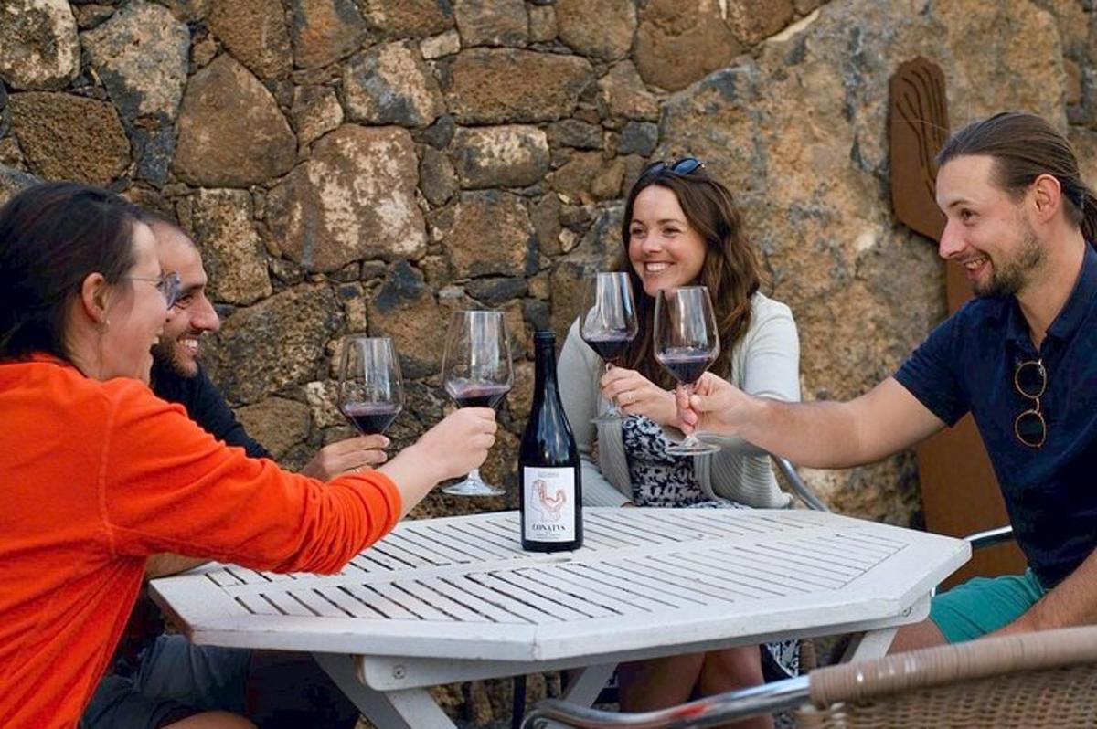 a group of people sitting around a table holding wine glasses
