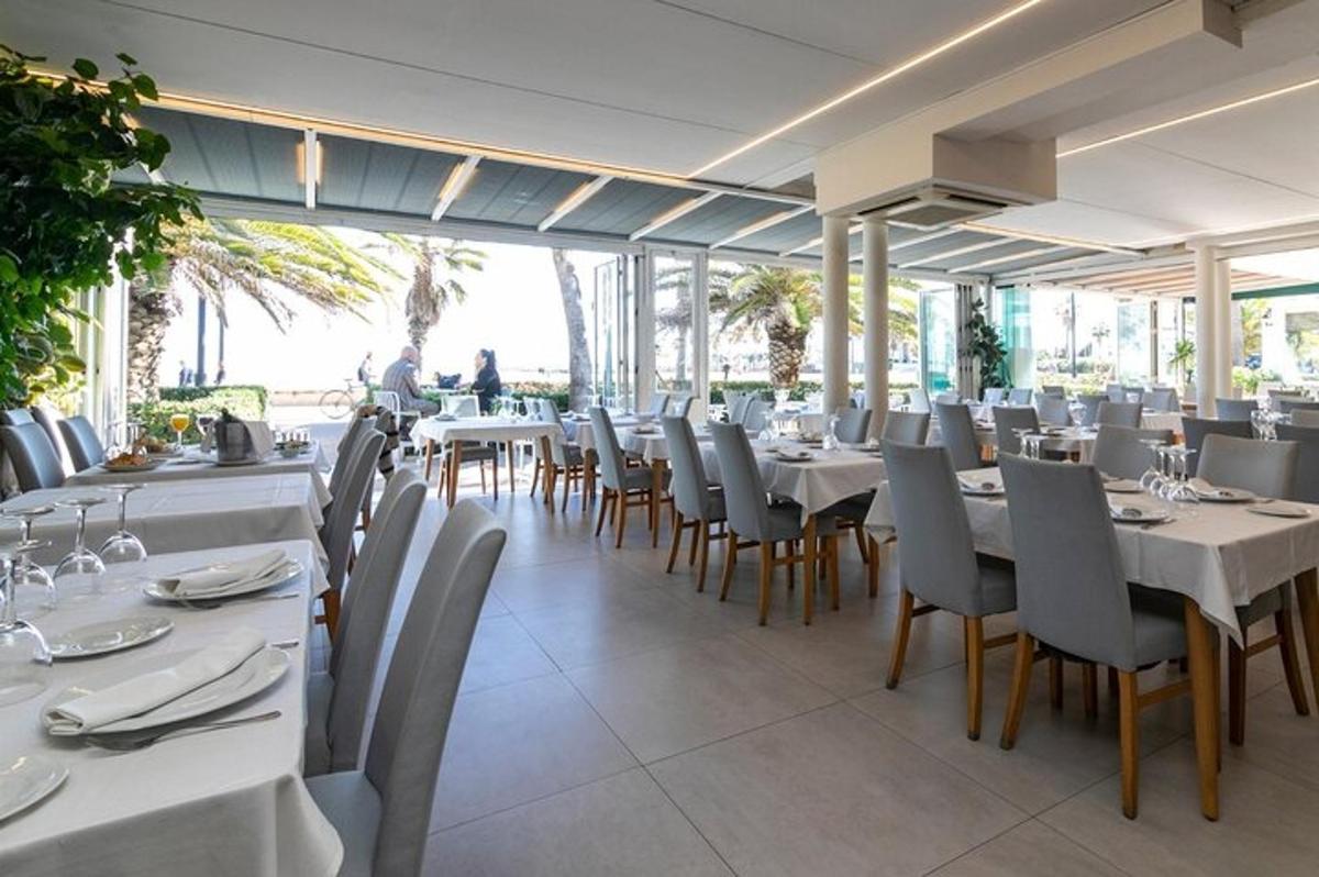uma sala de jantar com mesas e cadeiras brancas