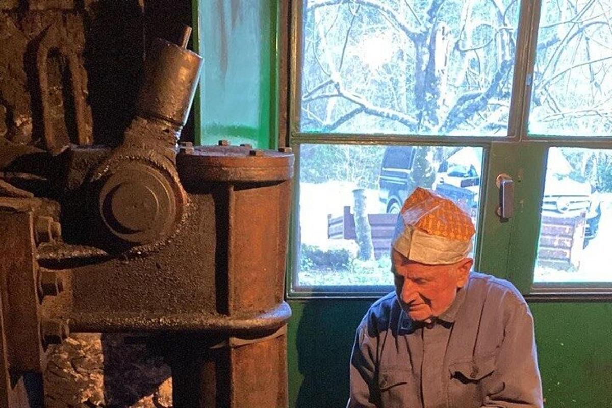 muž v kuchařské čepici sedící v místnosti