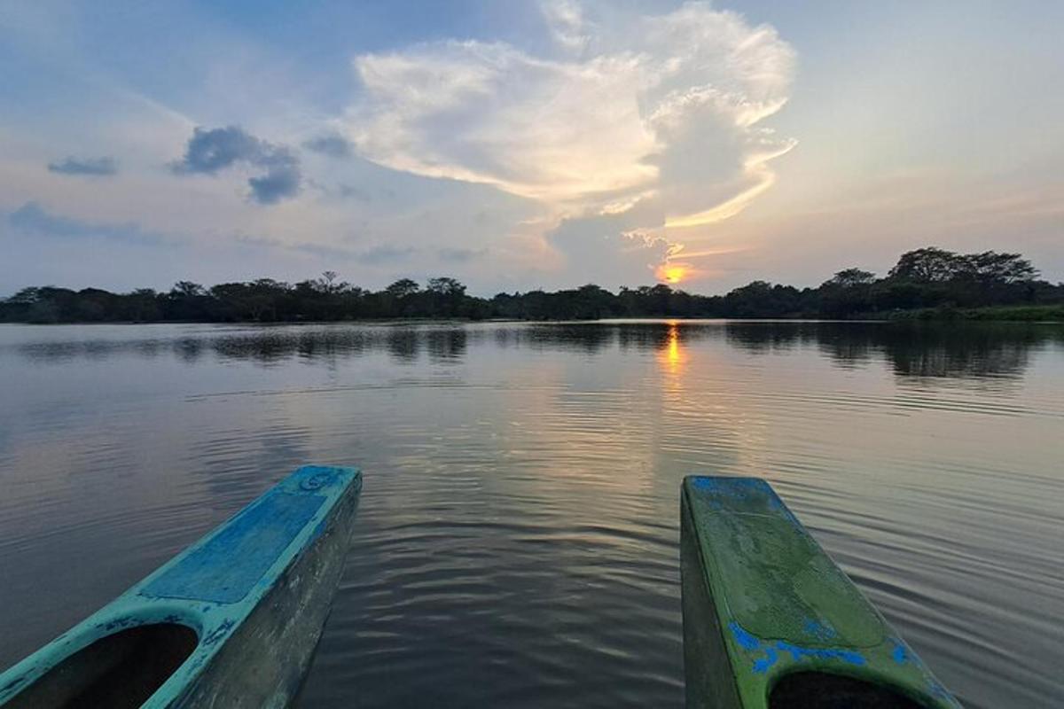 Un barco en el agua con la puesta de sol de fondo