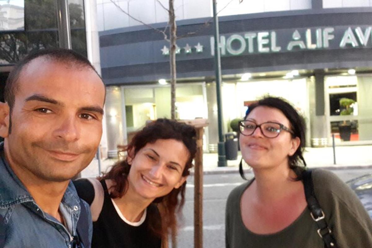 moški in dve ženski stojita pred hotelom