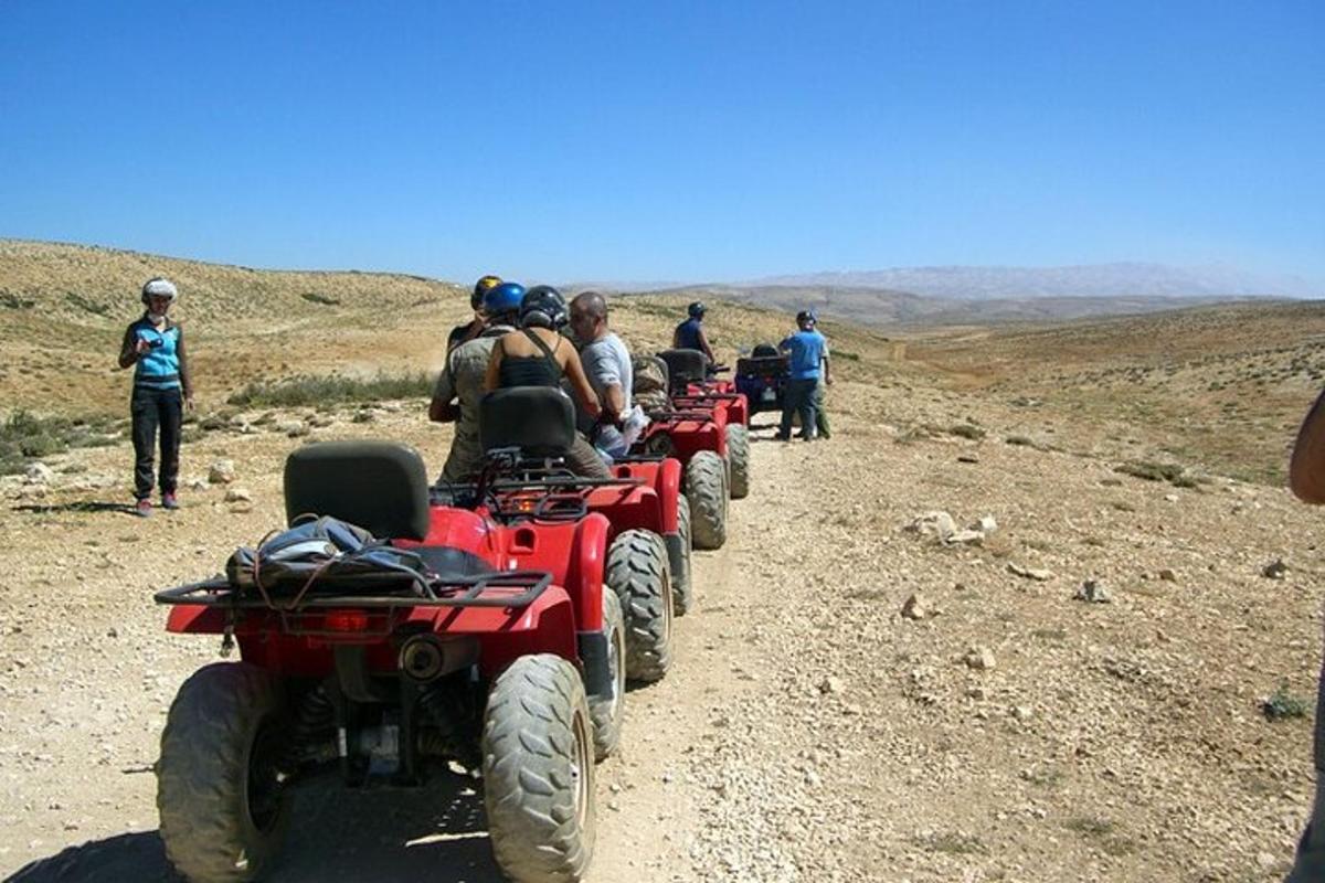 un gruppo di persone che guidano quad su una strada sterrata