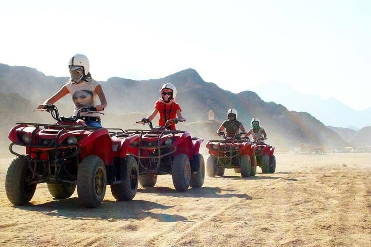 un gruppo di persone in sella a quad nel deserto