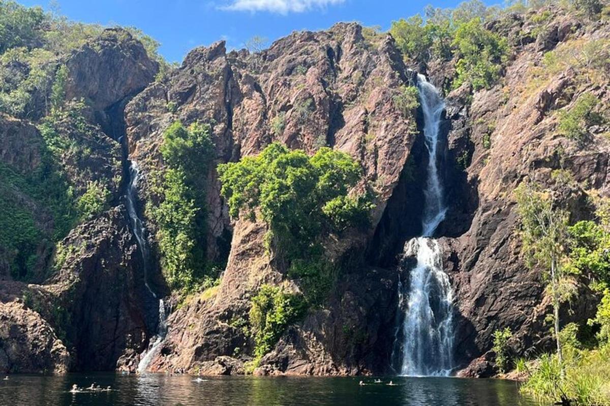 a waterfall on the side of a mountain next to a lake