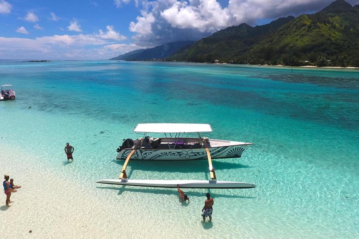 a boat on a beach with people in the water