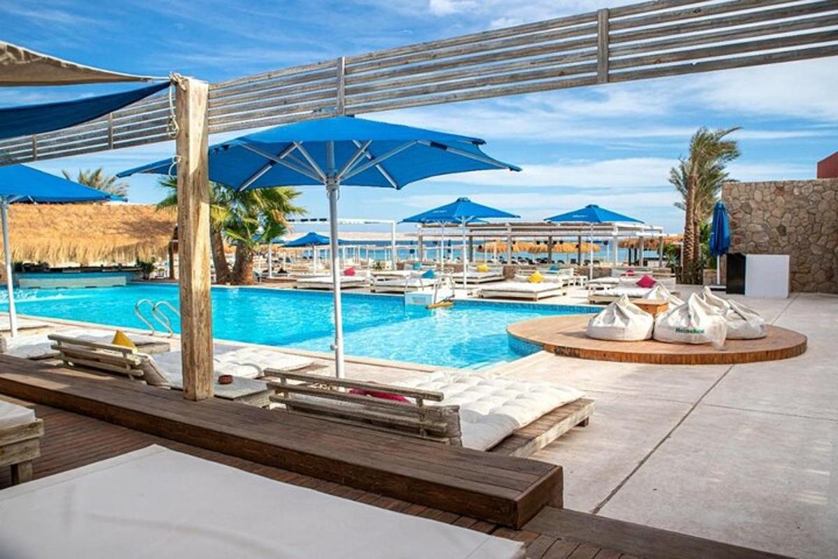 una piscina con sedie e ombrelloni in un resort