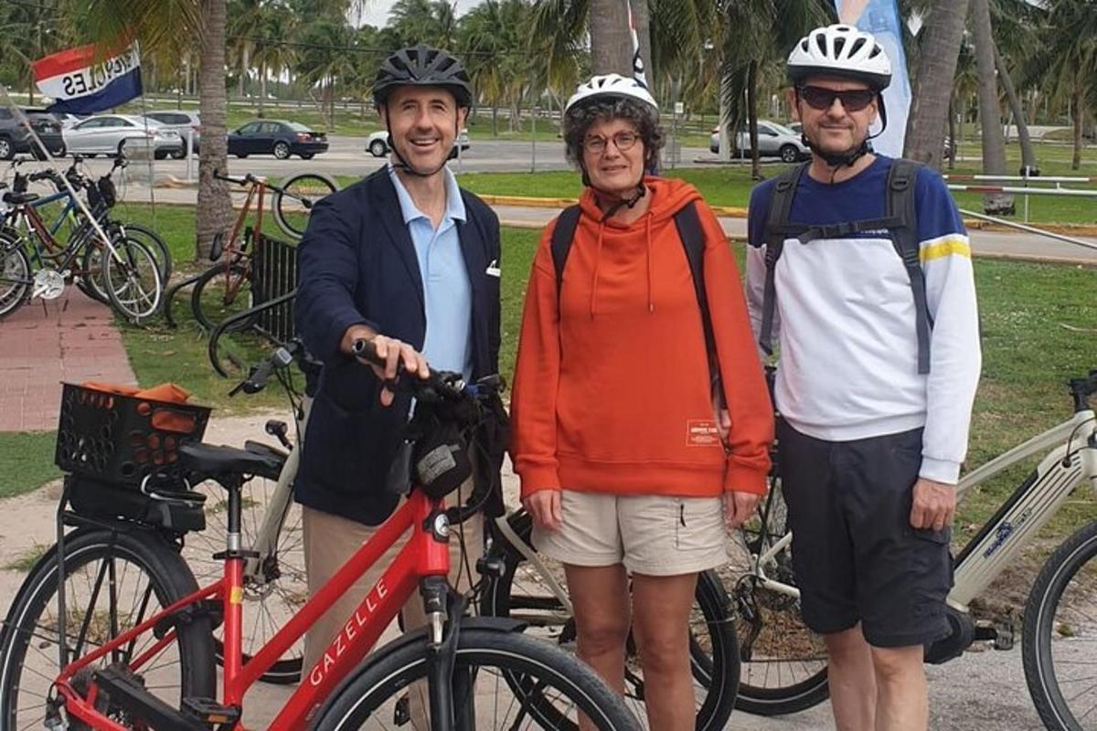 Tres personas con cascos de pie junto a sus bicicletas.