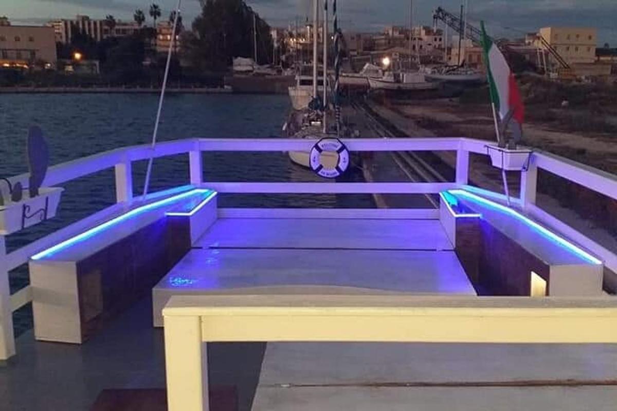 Un banco morado sentado en un muelle junto al agua.