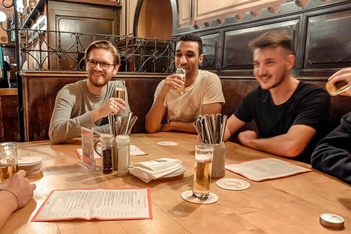 un grup d'homes asseguts al voltant d'una taula bevent cervesa