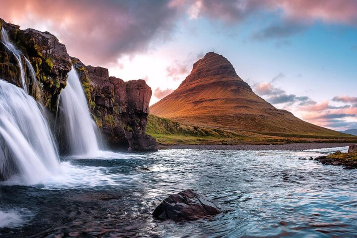 una cascata di fronte a una montagna con un lago