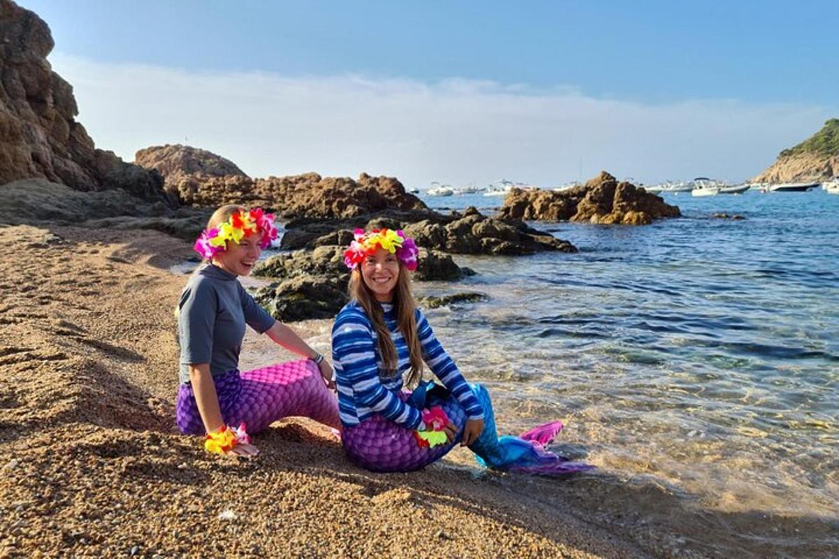 due bambini piccoli seduti sulla spiaggia