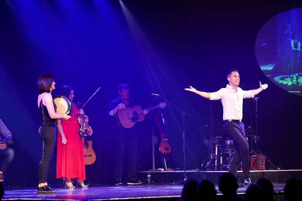 a man dancing on a stage with a group of musicians