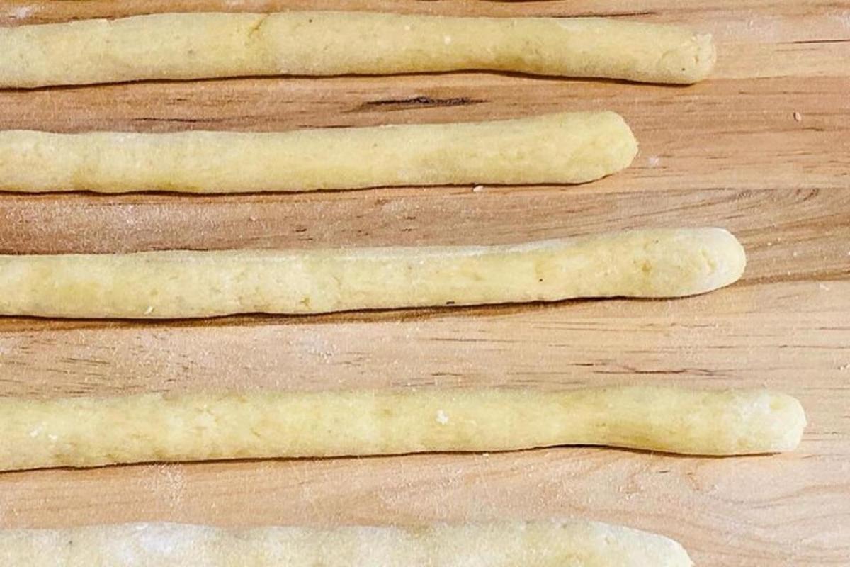 quattro grissini crudi appoggiati su un tavolo di legno