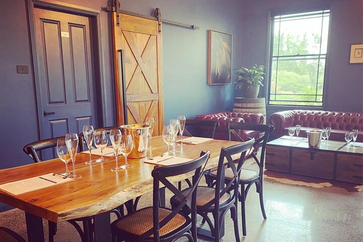 a wooden table with chairs and wine glasses on it
