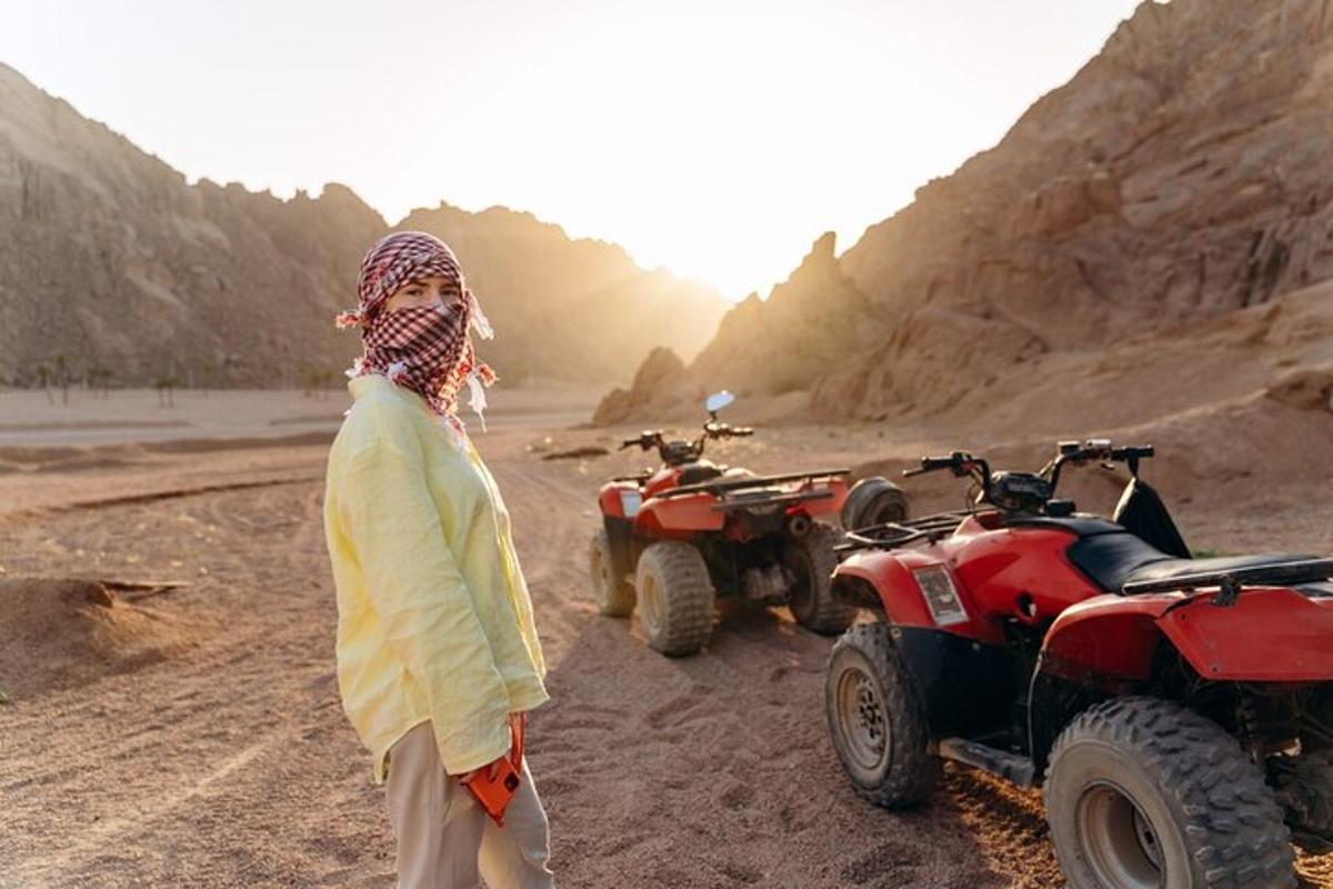 una donna in piedi nel deserto con due quad