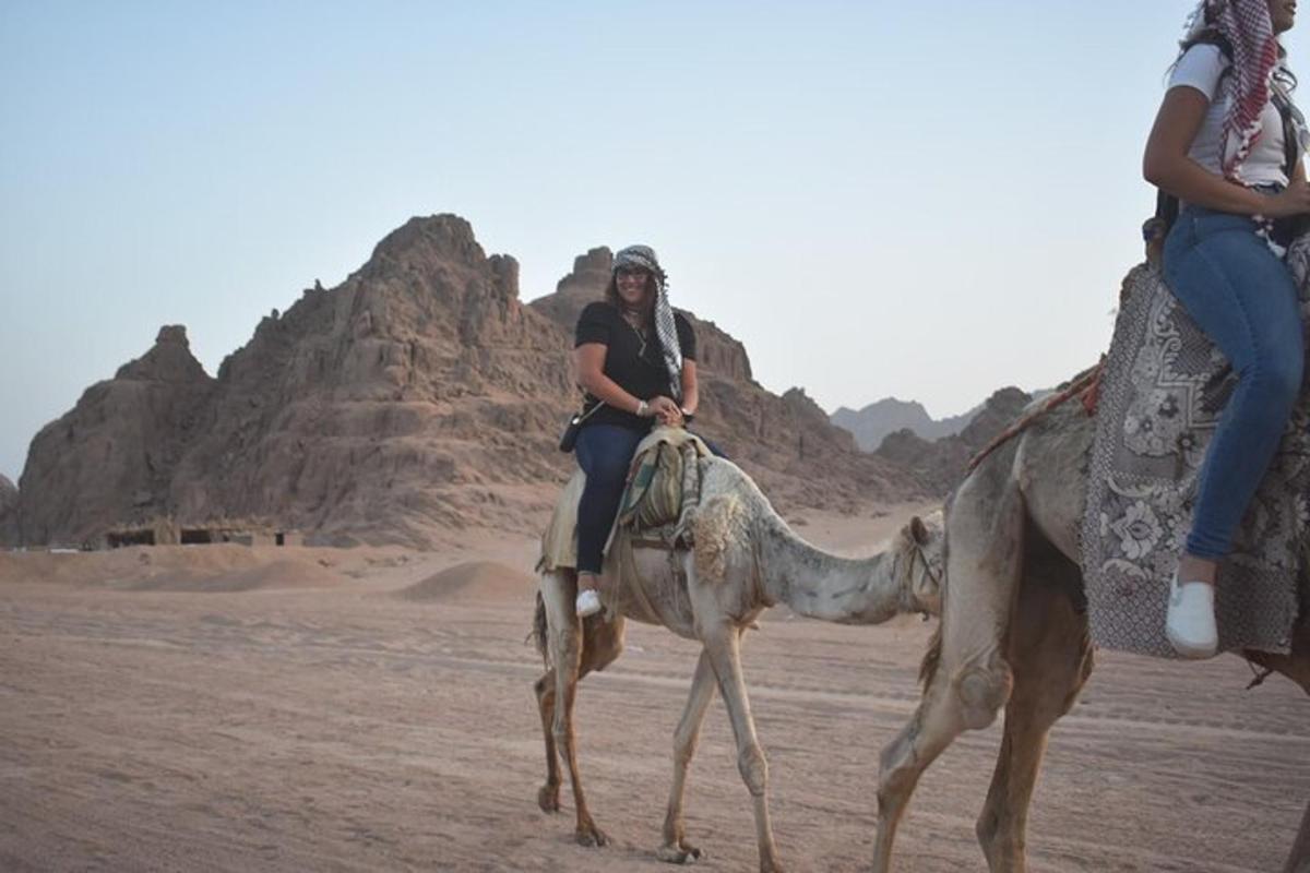 due donne a cavallo di un cammello nel deserto