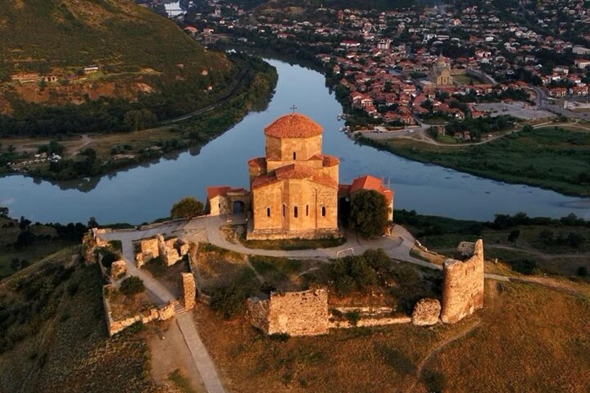 una vista aerea di un castello su una collina vicino a un fiume