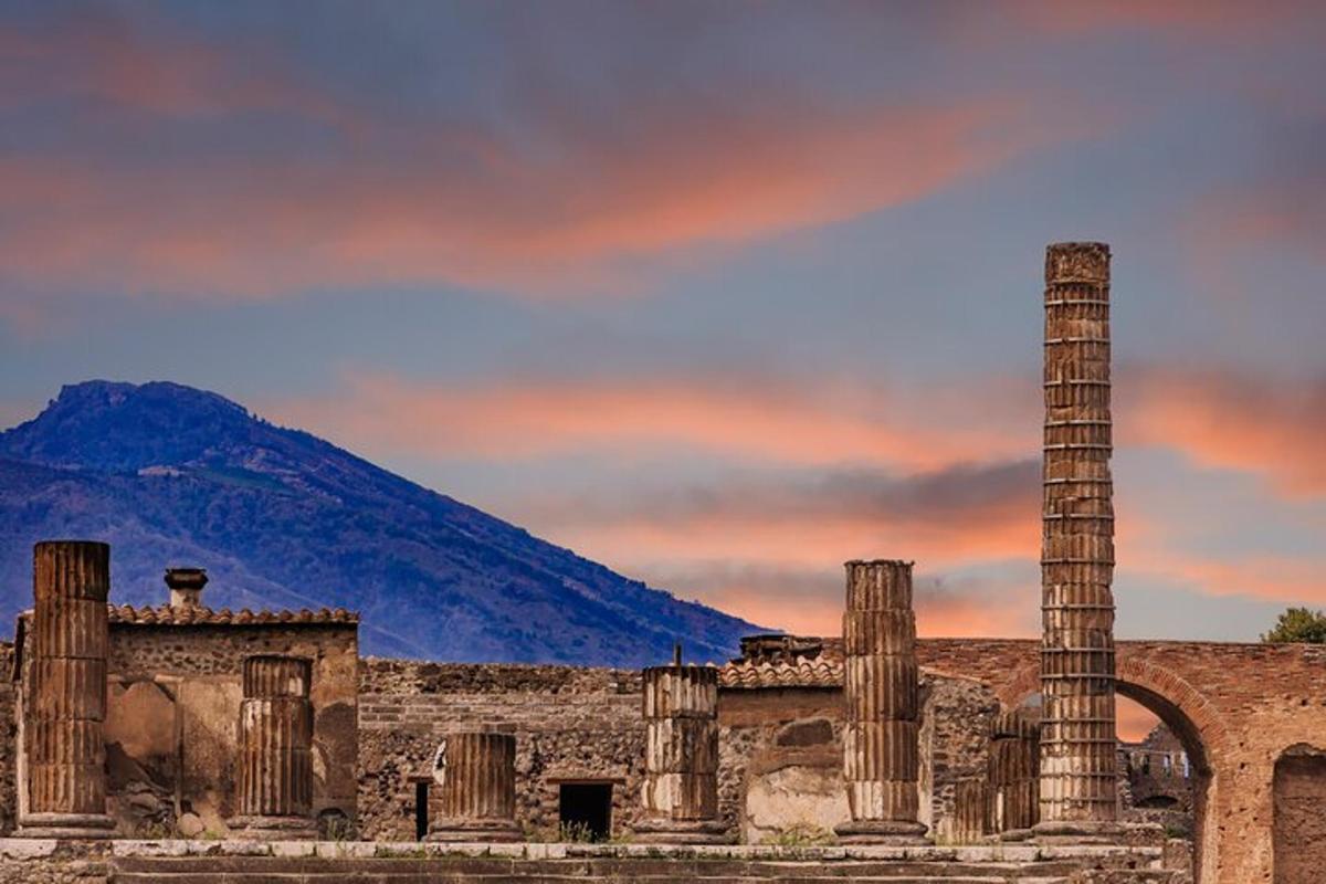 an ancient building with columns and a mountain in the background