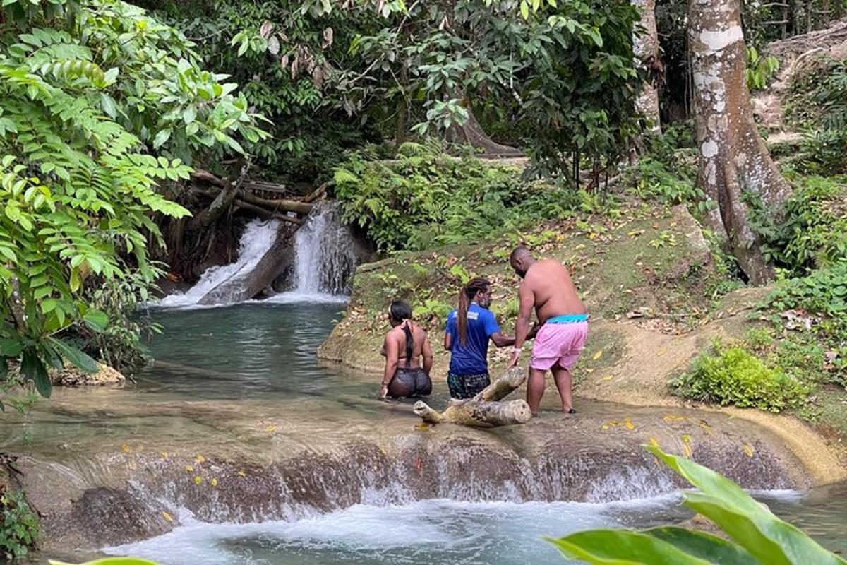 sekumpulan orang berdiri di hadapan air terjun