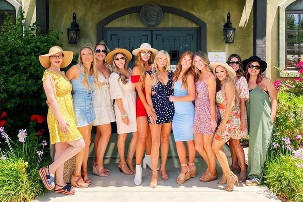 a group of women standing in front of a house