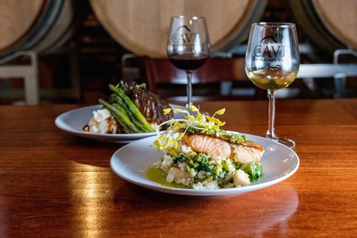 two plates of food on a wooden table with wine glasses