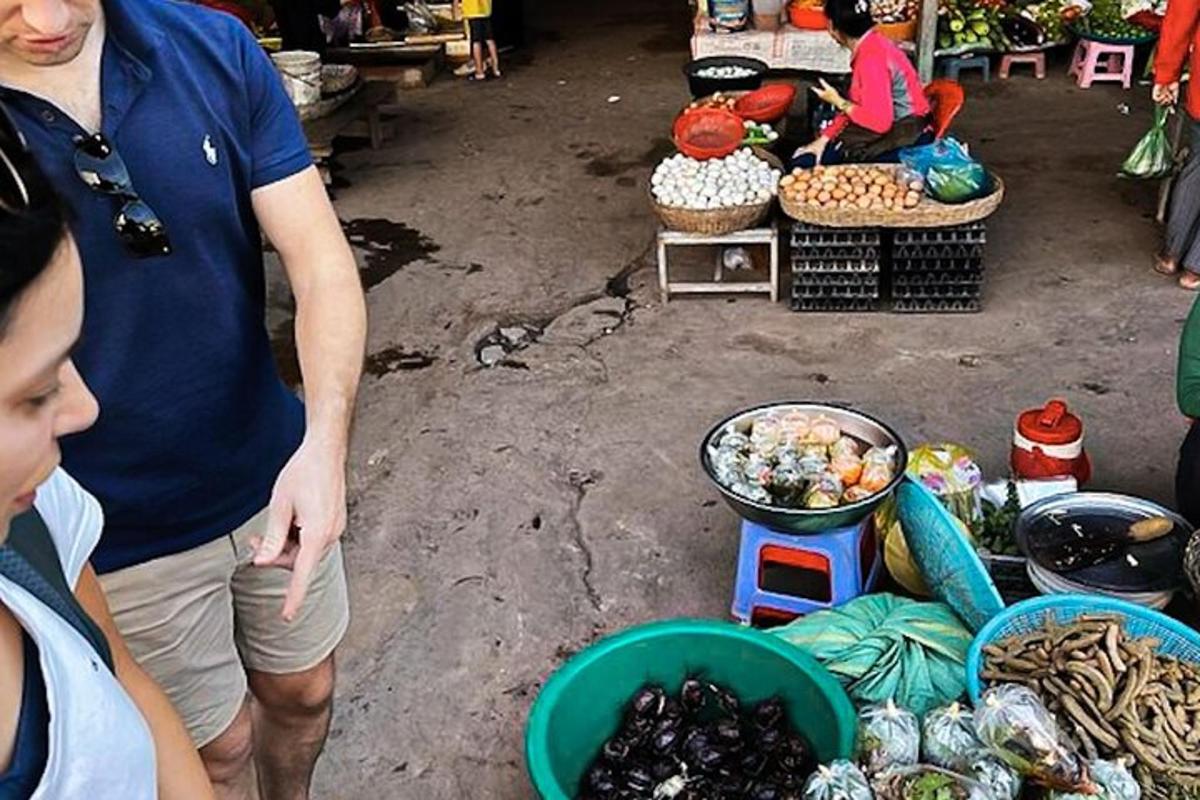 moški, ki stoji na tržnici s kupom hrane