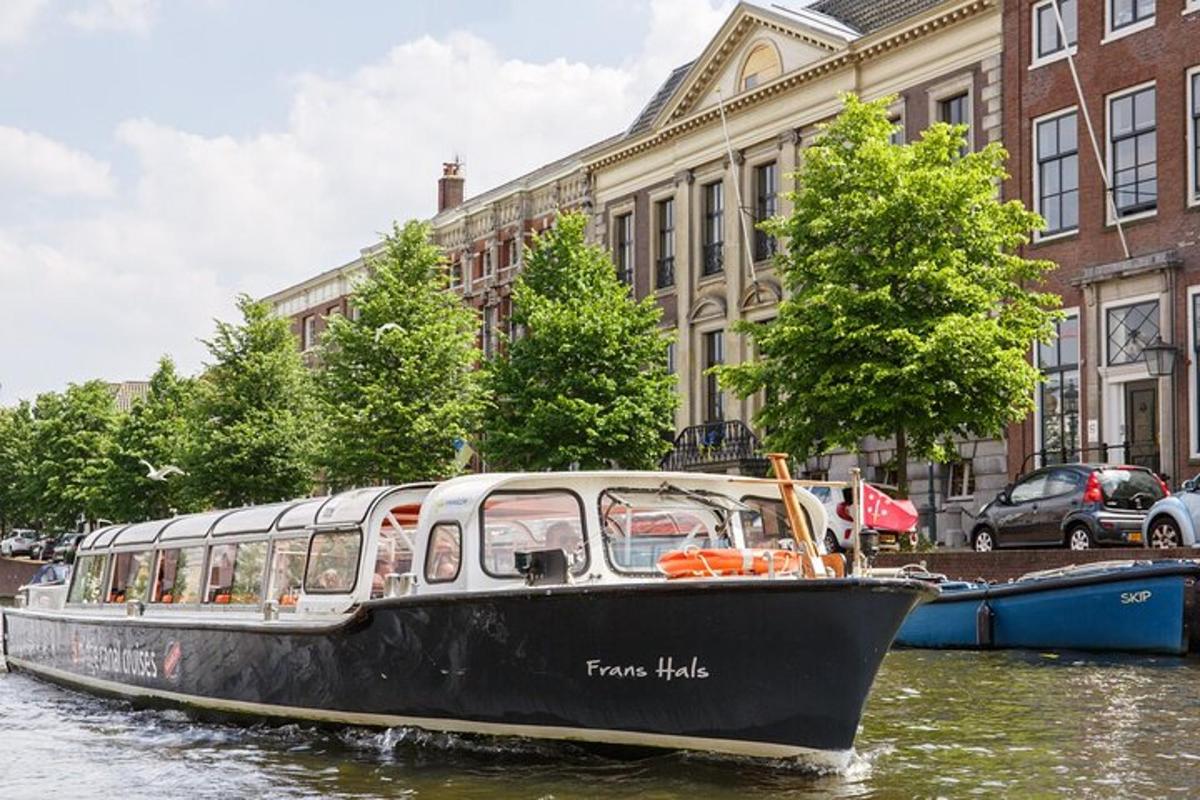 um barco preto e branco em um rio em uma cidade