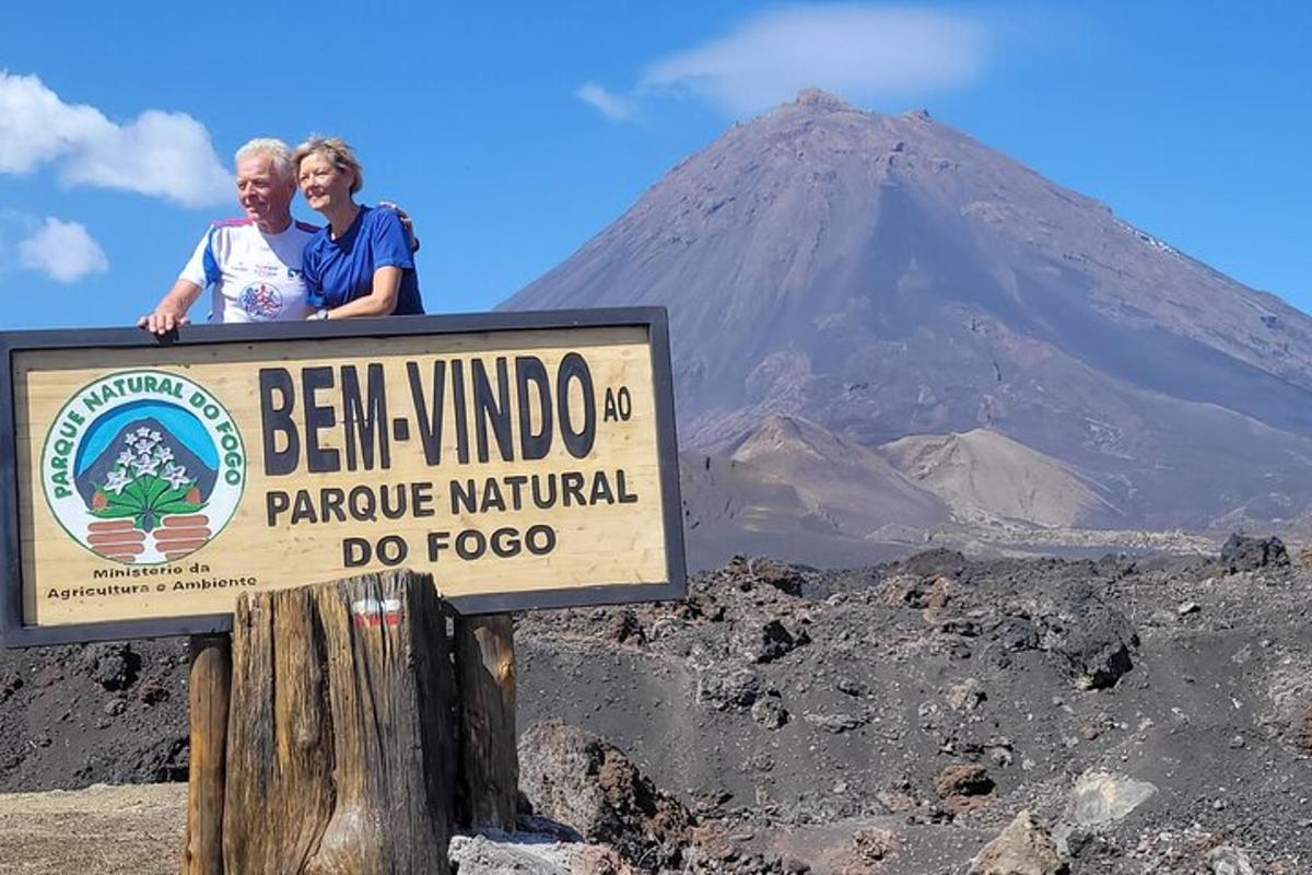 a man and woman standing on a sign in front of a mountain