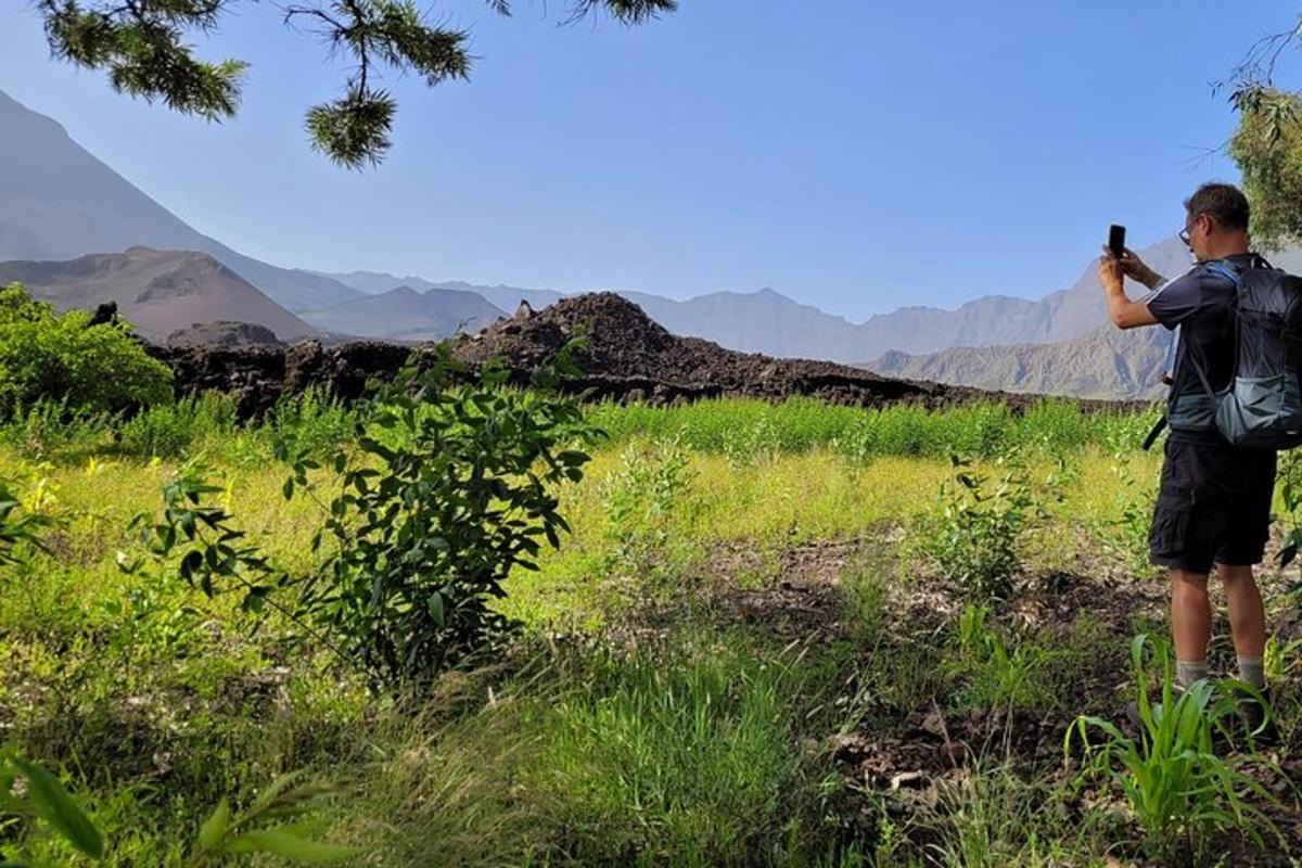 a man with a backpack taking a picture of the mountains
