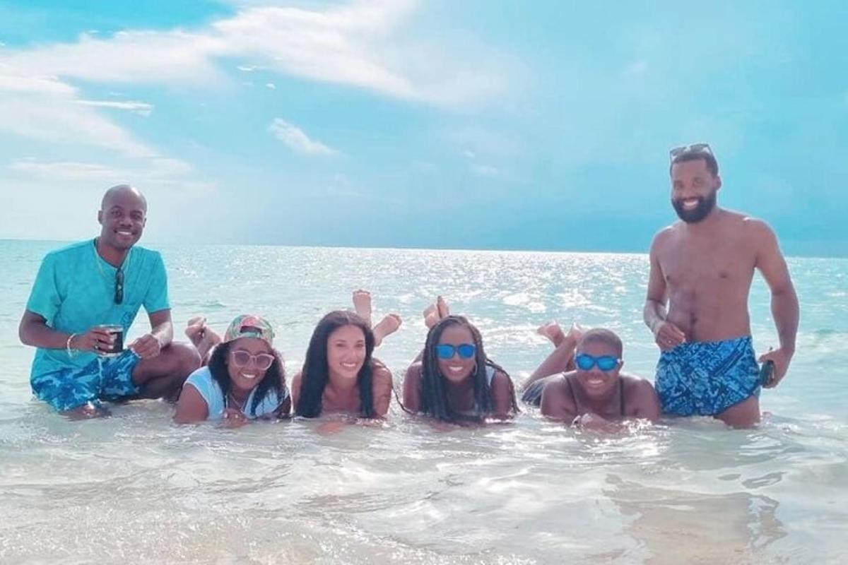 a group of people sitting in the water on the beach