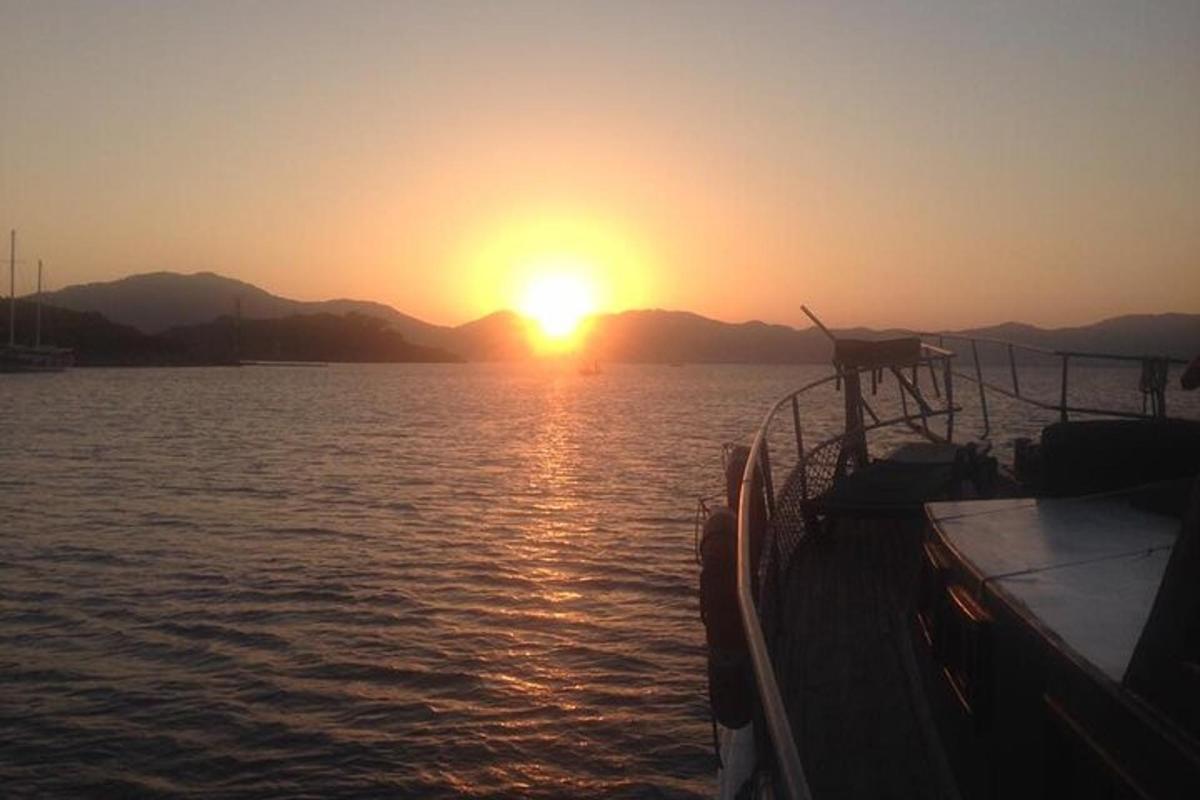 una barca in acqua con il tramonto sullo sfondo