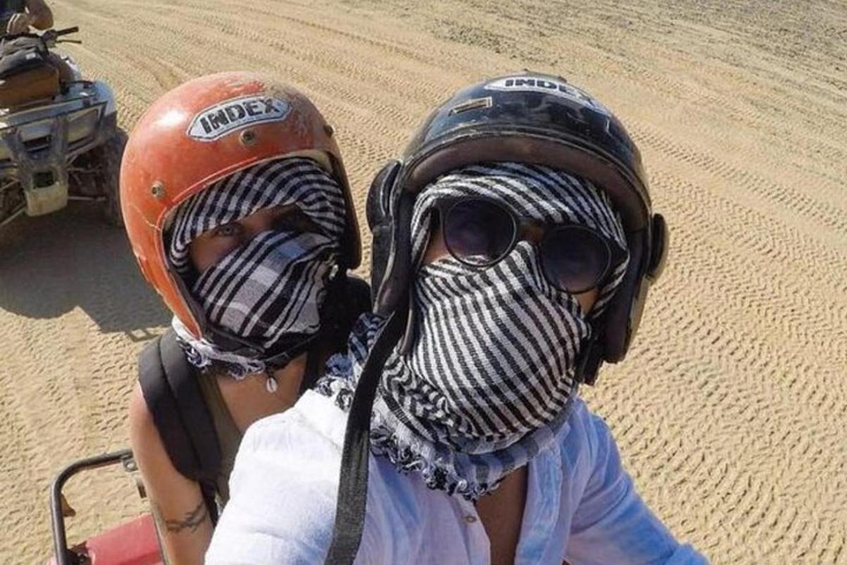 two people on a motorcycle in the desert