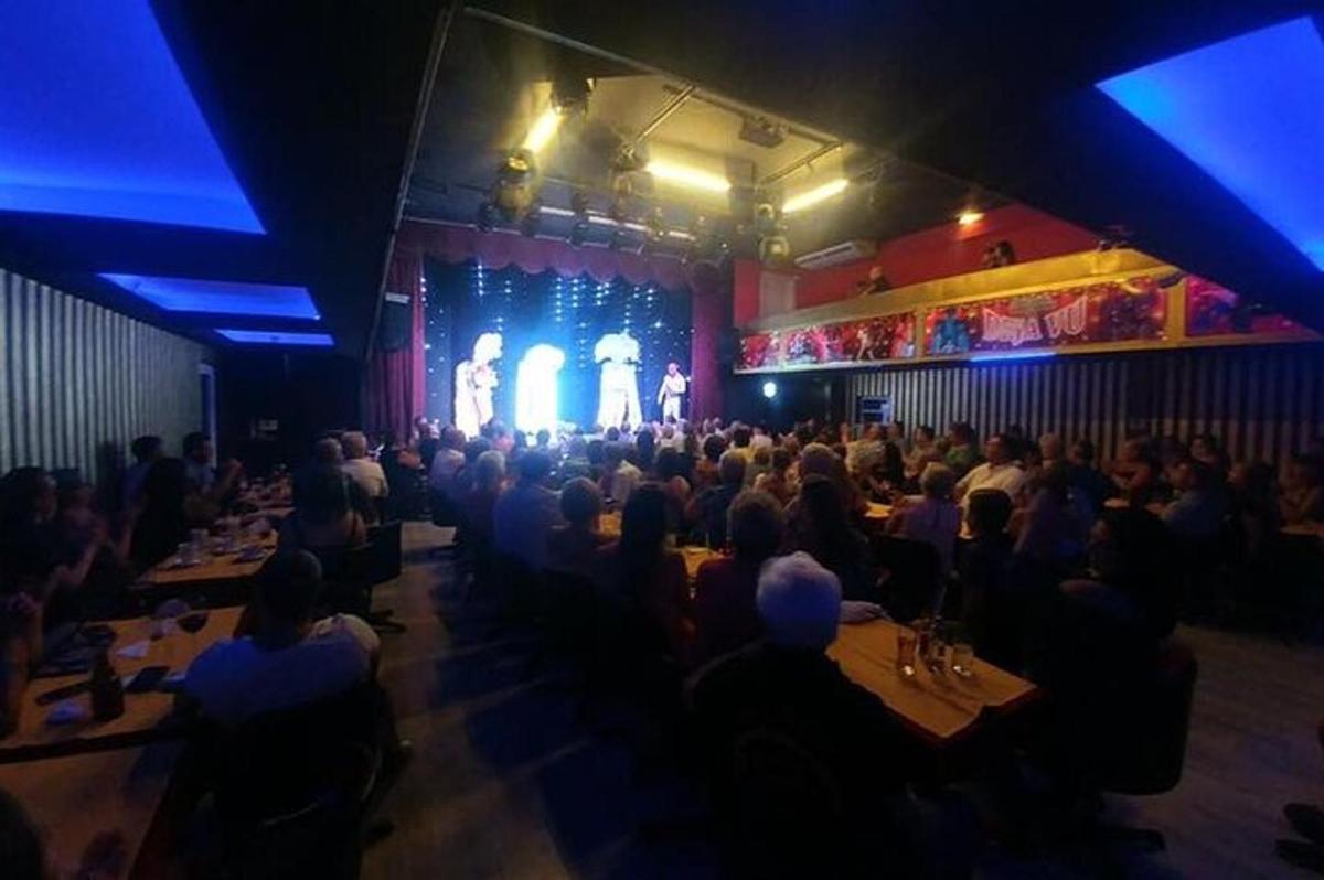 eine Menschenmenge, die an Tischen in einem Theater sitzt