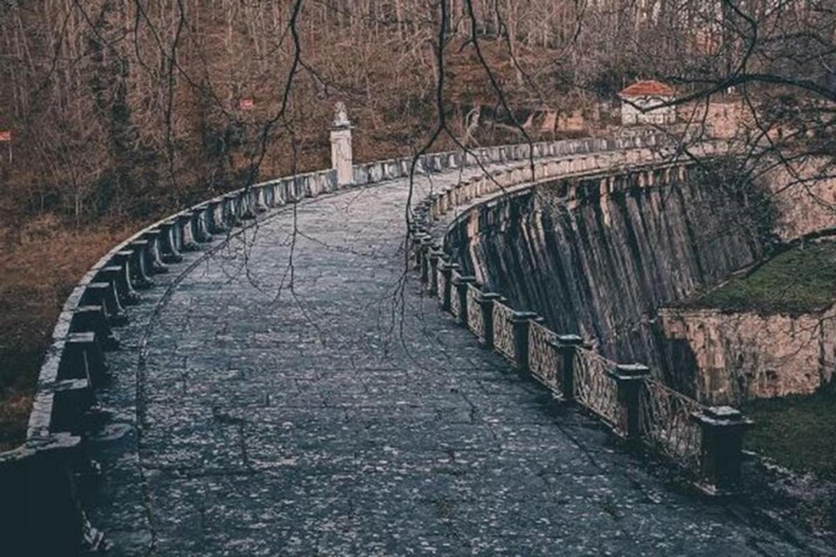 kamenný most přes řeku se sochou