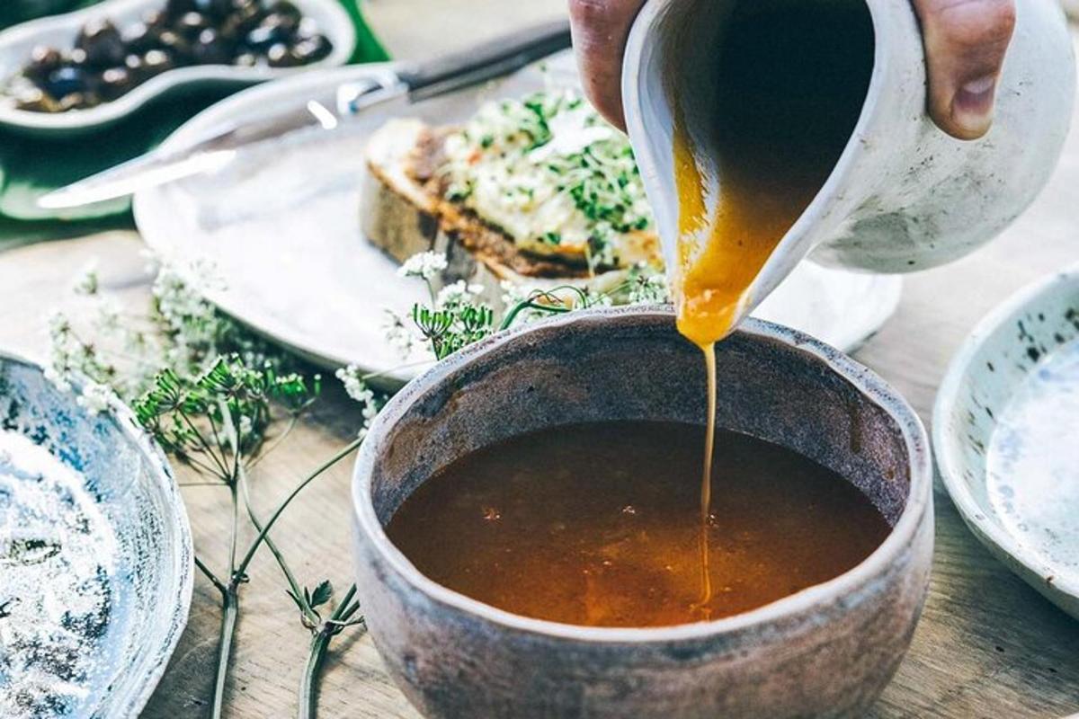a person is pouring sauce into a bowl of soup