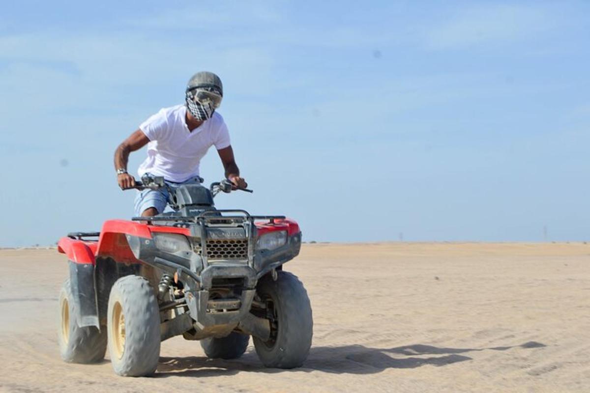 un uomo in sella a un quad nel deserto