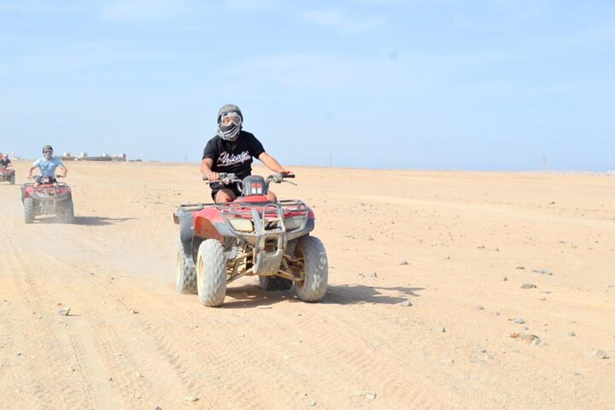 due persone stanno guidando dei quad nel deserto