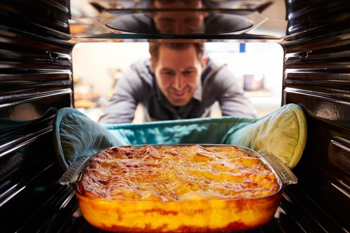 isang lalaki ang naglalagay ng pizza sa oven